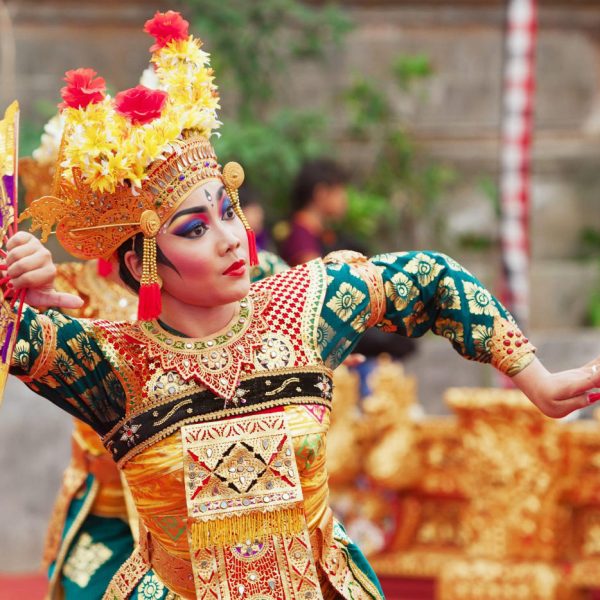 BALI ISLAND INDONESIA - JUNE 28 2015: Beautiful woman dressed in colorful sarong - Balinese style female dancer costume dancing traditional temple dance Legong at Bali Art and Culture Festival show