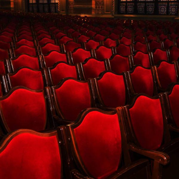 Interior theater art. Audience with empty soft armchairs of Opera and Ballet Theater is waiting for audience. Empty interior of concert theater before performance and without spectators. Soft focus