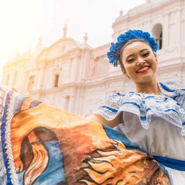 Nicaraguan folklore dancer smiling and looking at the camera outside the cathedral church in the central park of the city of Leon. The woman wears the typical dress of Central America and similar to countries of South America